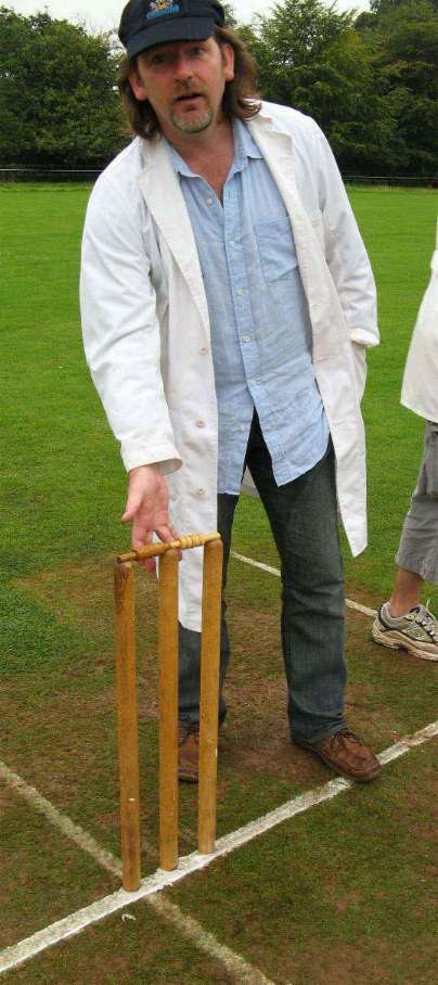 Special-guest umpire, the charity rocker Bono, removes the bails